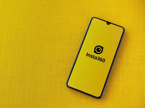 Lod, Israel - July 16,2023: Insta360 app launch screen on smartphone on yellow fabric background. Top view flat lay with copy space.