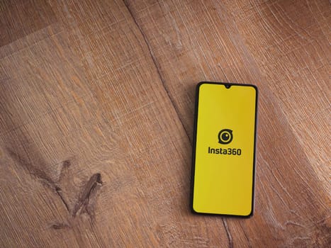Lod, Israel - July 16,2023: Insta360 app launch screen on smartphone on wooden background.. Top view flat lay with copy space.