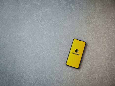 Lod, Israel - July 16,2023: Insta360 app launch screen on smartphone on ceramic stone background.. Top view flat lay with copy space.
