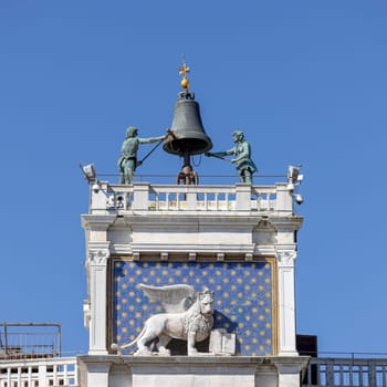 Venice, Italy - September 27, 2023: St Mark's Clock tower (Torre dell’Orologio) on Piazza San Marco, Lion of Saint Mark relief on facade. Winged Lion of Venice is a symbol of the city.