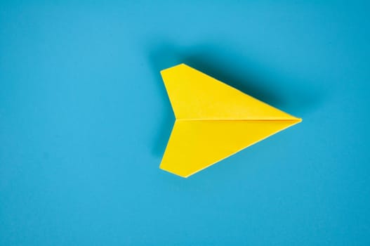 Low view of yellow paper plane origami leading white paper planes. With copy space for text