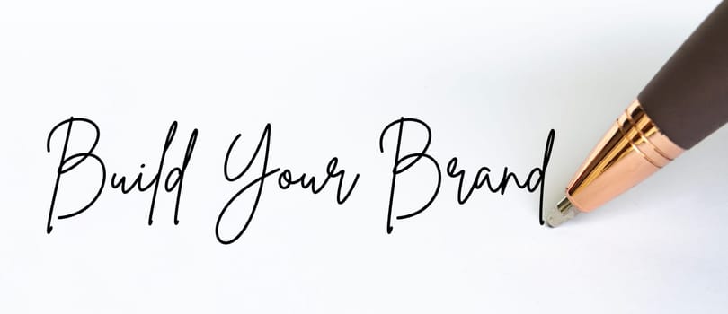 Build your brand text written on white notepad.