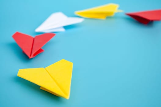 Low view of yellow paper plane origami leading white paper planes. With copy space for text