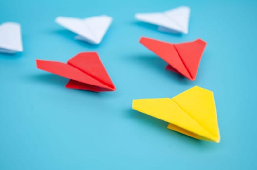 Low view of yellow paper plane origami leading white paper planes. With copy space for text