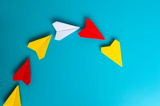 Low view of yellow paper plane origami leading white paper planes. With copy space for text