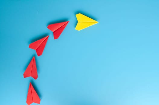 Low view of yellow paper plane origami leading white paper planes. With copy space for text