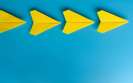 Top view of yellow paper airplanes with space for text.