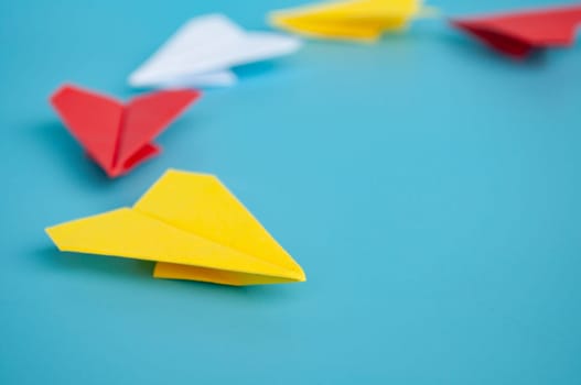 Low view of yellow paper plane origami leading white paper planes. With copy space for text