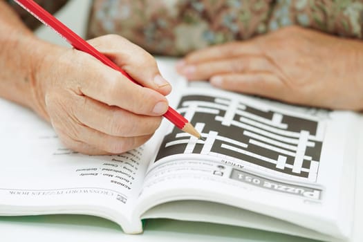 Bangkok, Thailand - May 15, 2022 elderly woman playing sudoku puzzle game for treatment dementia prevention and Alzheimer disease.