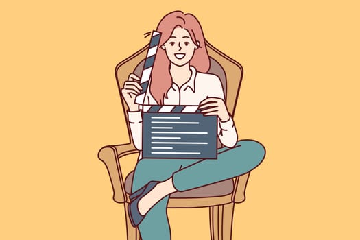 Woman film producer holds clapperboard and smiles sitting in chair to invite actors to participate in casting. Girl director demonstrates clapperboard after completing shooting of next take