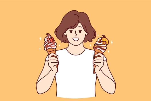 Teenage woman holds two ice creams with fruit syrup and waffle cone and looks at screen smiling. Child offers to try delicious and sweet ice creams to refresh yourself in hot summer weather