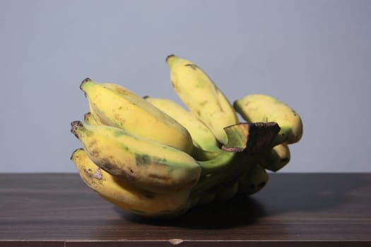 Banana fruit with wooden table on blurred background