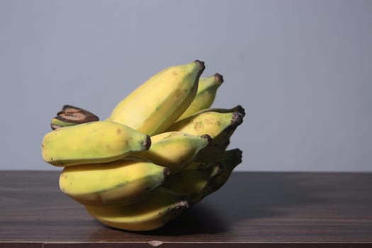 Banana fruit with wooden table on blurred background