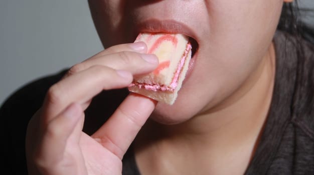 Woman eating cake deliciously, Soft blurred background