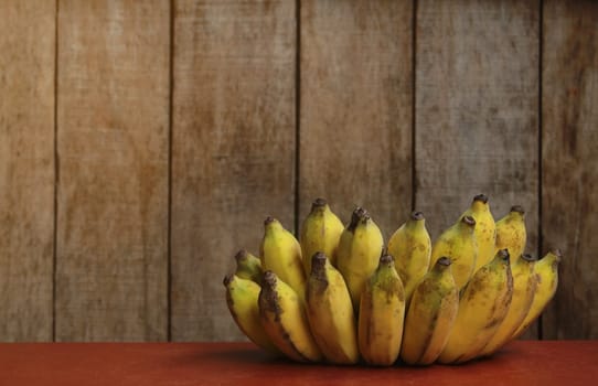 Banana fruit with wooden table on blurred background