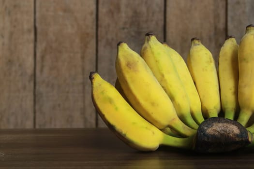 Banana fruit with wooden table on blurred background