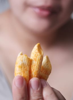 Woman holding crispy cornflakes for eat, It is a popular street food that is delicious and commonly found in Asian countries such as Thailand, China, Laos, Vietnam, and Burma.