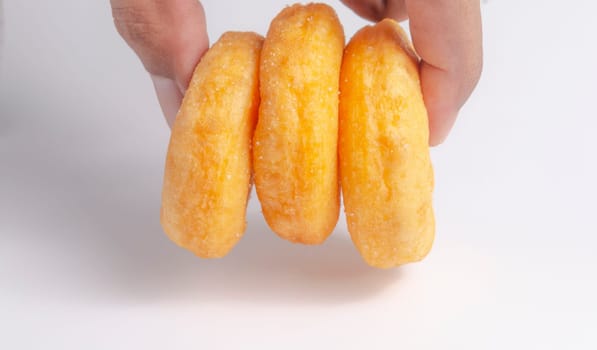 Hand with Donuts cake bakery sprinkled with sugar on white background
