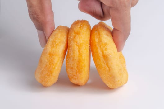Hand with Donuts cake bakery sprinkled with sugar on white background