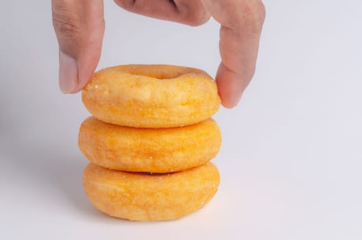 Hand with Donuts cake bakery sprinkled with sugar on white background