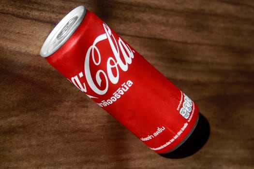 PHUKET, THAILAND - OCTOBER 01, 2023: Coca Cola, Can sweet and fizzy soft drink original that is popular all over the world, Dark blurred background