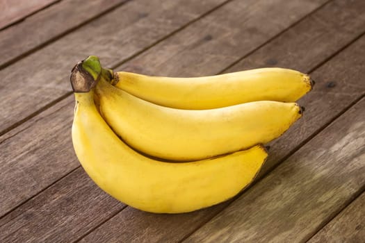 Banana fruit with wooden table on blurred green background