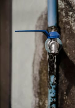 Wasting water - water drop from water tap, Leaky or tap, water tap in remote area, Deteriorated and dirty tap that everyone in the village uses to drink, which is located in a remote area It reflects the insufficiency of government agencies' water supply and the low quality of life of people in remote areas