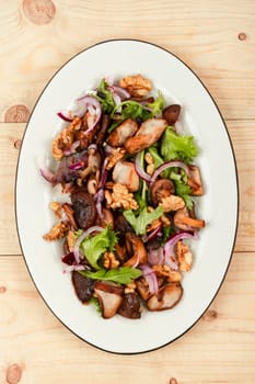 Homemade salad with roasted mushroom, red onion, herbs and walnuts. Healthy vegetarian food