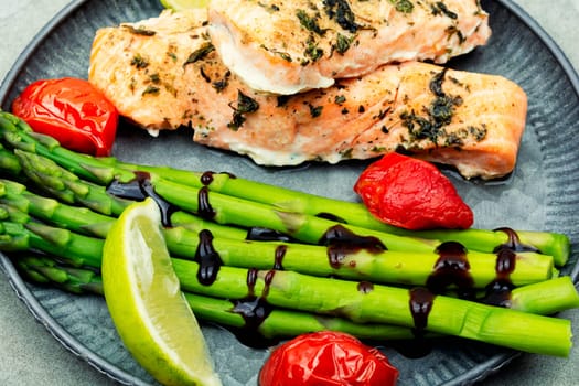 Baked trout and boiled asparagus on the plate. Mediterranean food