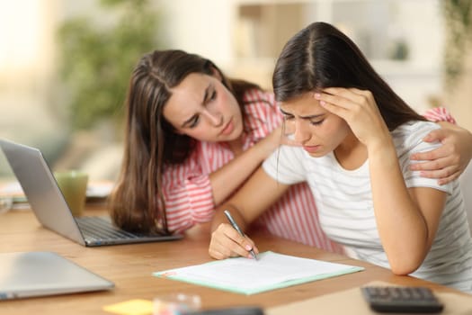 Worker comforting a sad colleague signing contract tele working at home