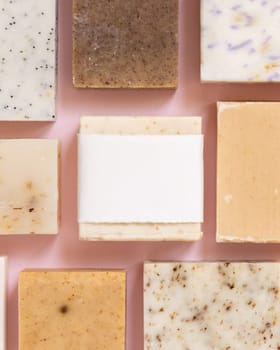 Beige and brown handmade soap bars on light pink top view, soap packaging mockup, copy space. Natural herbal products for for face and body care. Using organic handmade skincare products