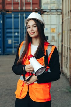 Woman Engineer with megaphone at industrial stock or terminal
