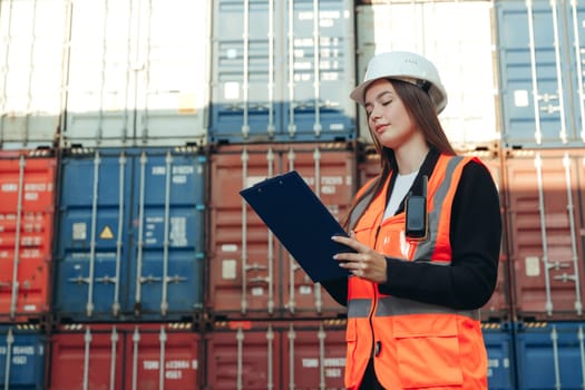 Woman Works in international shipping area Export and import delivery service with containers