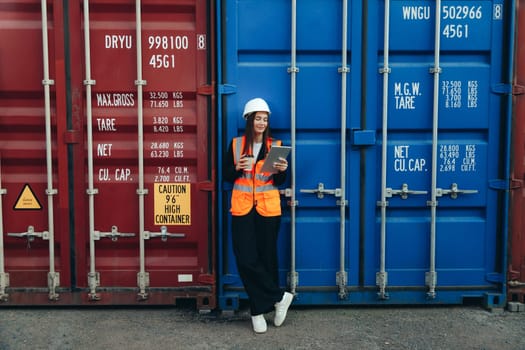 Female Engineer with Clip Folder in white helmet and vest working in container terminal port or construction site.