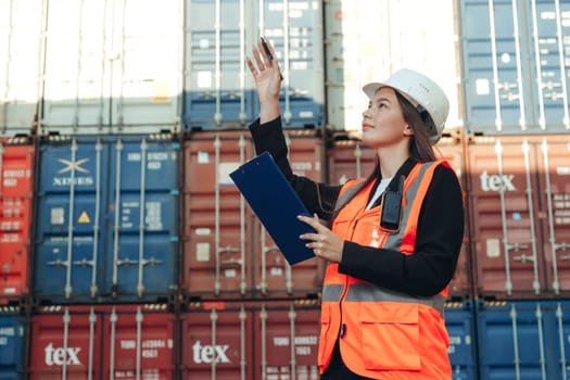 Female engineer with clip folder wearing white helmet and vest in container terminal port