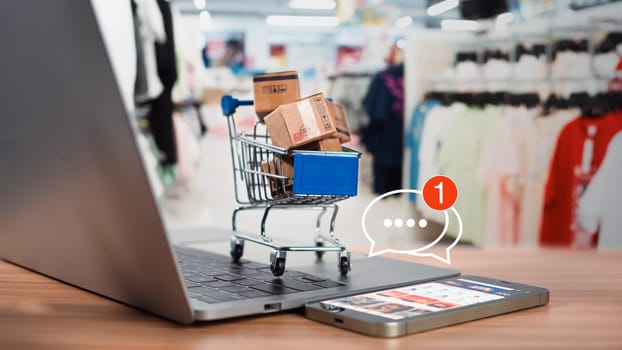 Shopping carts and product boxes Place on laptop computer showing online shopping concept, website, e-commerce, market platform, technology and online payment concept.