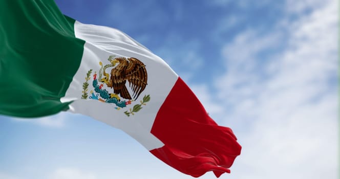 Mexico national flag waving on a clear day. Tricolor of green, white, and red with national coat of arms in the center of the white stripe. 3D illustration render. Rippled textile. Selective focus