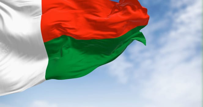 National flag of Madagascar waving in the wind on a clear day. Two horizontal bands of red and green, with a white vertical band on the left. 3d illustration render. Rippling fabric