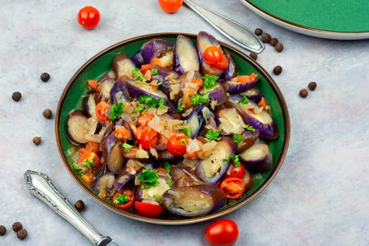 Warm purple eggplant, tomato and garlic salad. Copy space for text