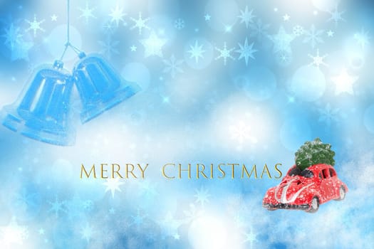 Christmas greeting card. A snow-covered red car toy with green fir-tree on the roof in a abstract winter christmas landscape with snowflakes and the incription Merry christmas.
