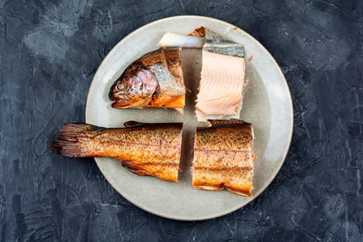 Dietary hot smoked trout salmon cut on a plate. Top view
