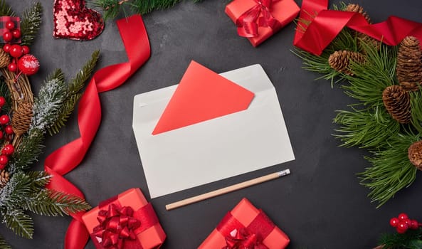 Christmas decor, gifts wrapped in red paper and a letter on a black background, top view