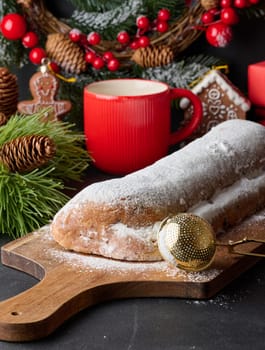 Christmas pastries stollen sprinkled with powdered sugar on the table, festive dessert