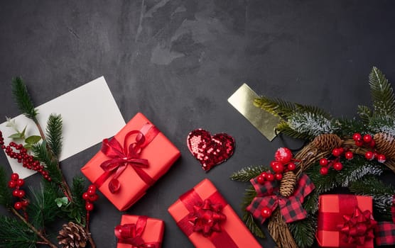 Christmas wreaths, fir branches and gifts on a black background. View from above. Copy space