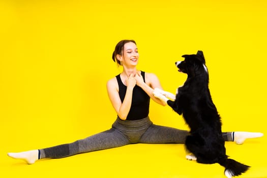 Shot of sport female in leggings with a border collie dog isolated on yellow and red background