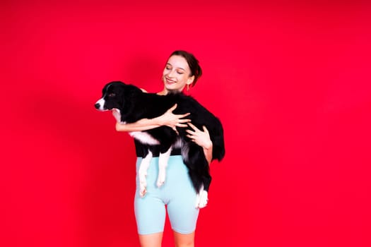 Shot of sport female in leggings with a border collie dog isolated on yellow and red background