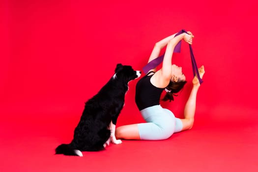 Shot of sport female in leggings with a border collie dog isolated on yellow and red background