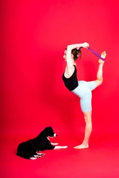 Shot of sport female in leggings with a border collie dog isolated on yellow and red background