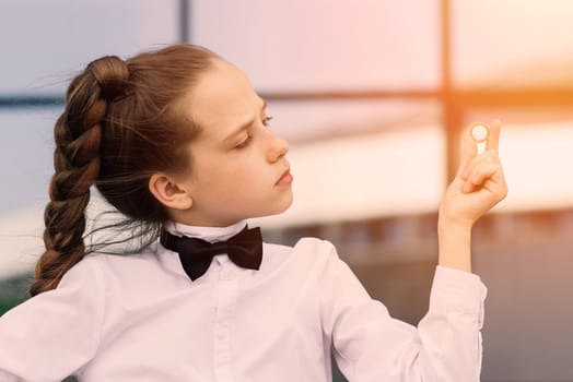 Portrait of cute caucasian teen girl holding coin. Saving money and business concept.