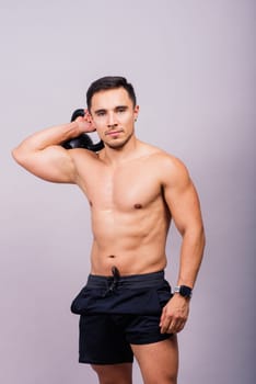 Full body of muscular man exercising with dumbbell on a white and dark background